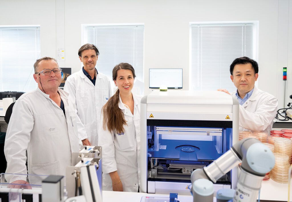 de AI-kolonieteller van waterlaboratorium van Vitens; v.l.n.r. Henk Stienstra Adrie Atsma, Fenna van Schuilenburg en Chi Wing Man