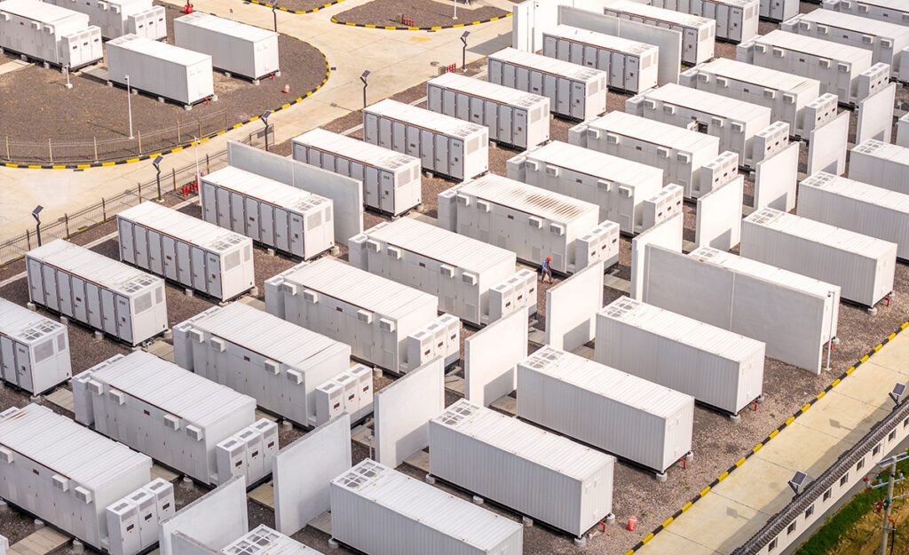 Netjes opgestelde rijen batterijpakketten in energieopslagcontainers op een industrieterrein